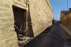 Ignobile atto vandalico, bruciato portone sotto le mura aragonesi