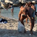 Turista francese raccoglie rifiuti alla spiaggia del Molo: «La gente si sta ormai abituando»