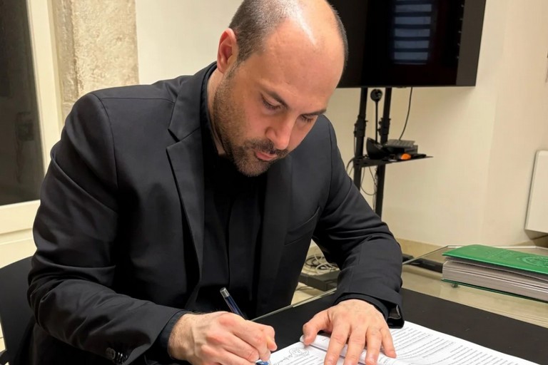 Don Francesco Colangelo firma i documenti